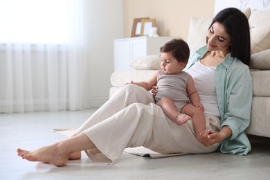 Photo of Happy mother with her cute little baby at home