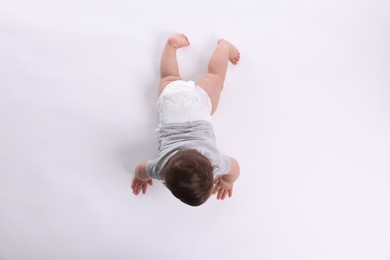 Photo of Cute little baby crawling on white background, above view