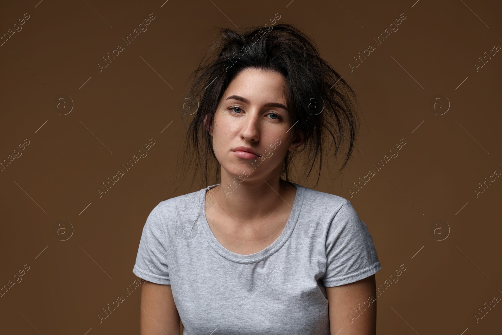 Photo of Woman suffering from hangover on brown background