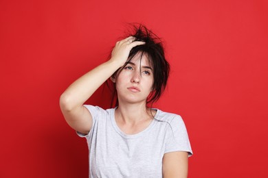 Photo of Woman suffering from hangover on red background