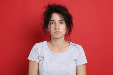 Photo of Woman suffering from hangover on red background