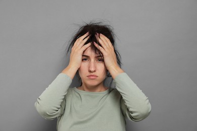 Photo of Woman suffering from hangover on grey background