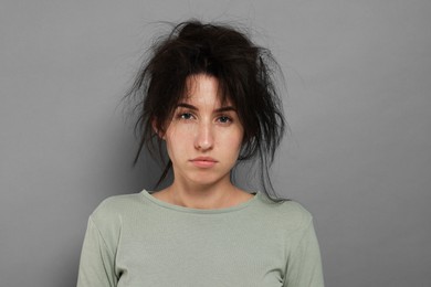 Photo of Woman suffering from hangover on grey background
