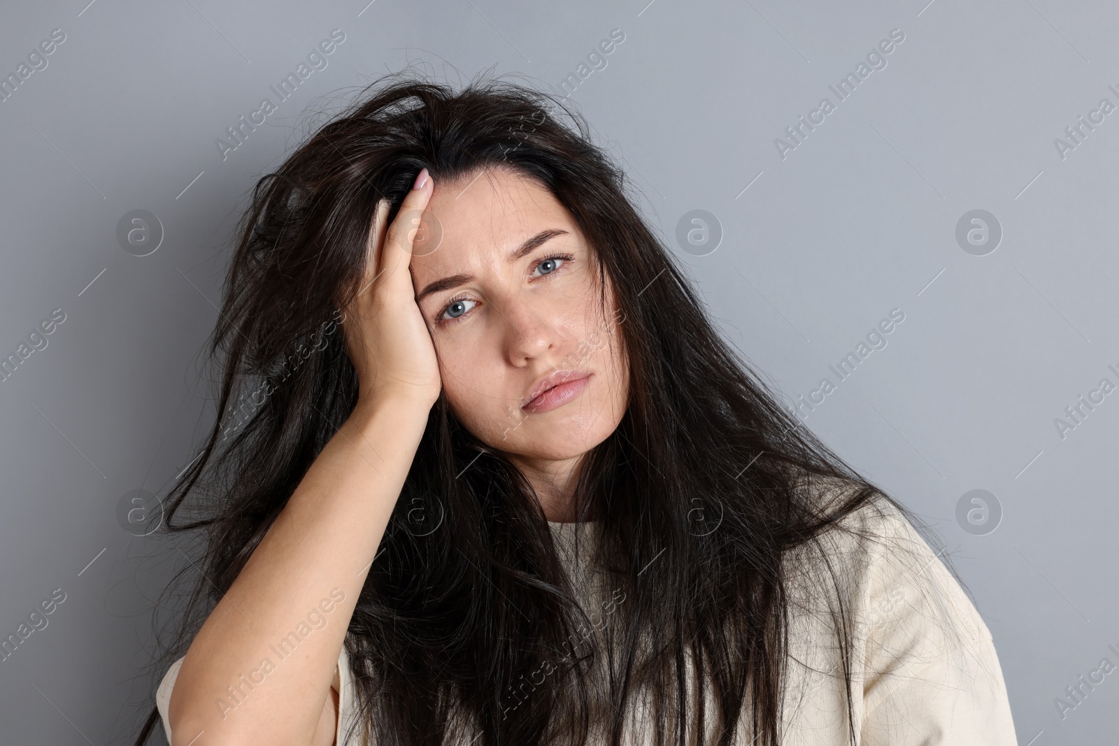 Photo of Woman suffering from hangover on grey background