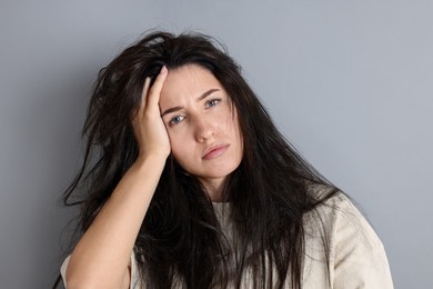 Photo of Woman suffering from hangover on grey background
