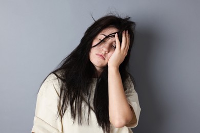 Photo of Woman suffering from hangover on grey background