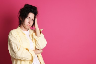 Photo of Woman suffering from hangover on crimson background, space for text