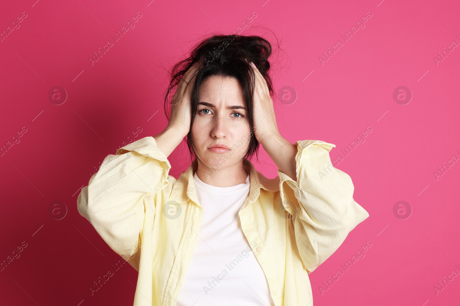 Woman suffering from hangover on crimson background Photo of Woman suffering from hangover on crimson background