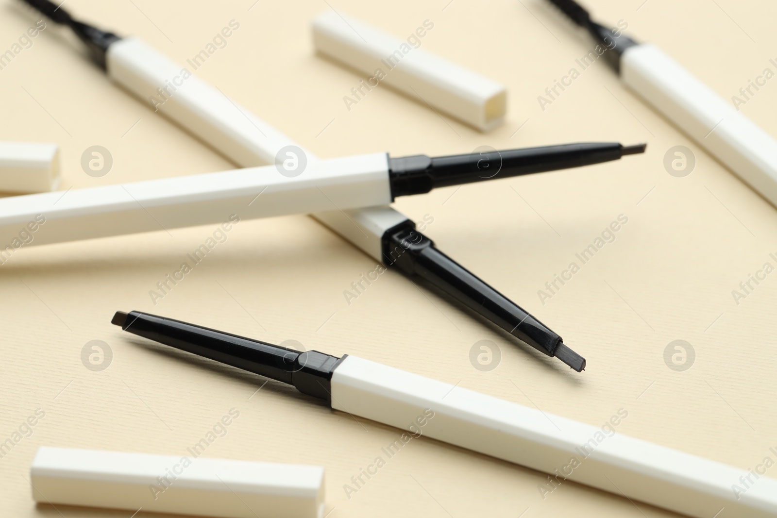 Automatic eyebrow pencils on beige background, closeup Photo of Automatic eyebrow pencils on beige background, closeup