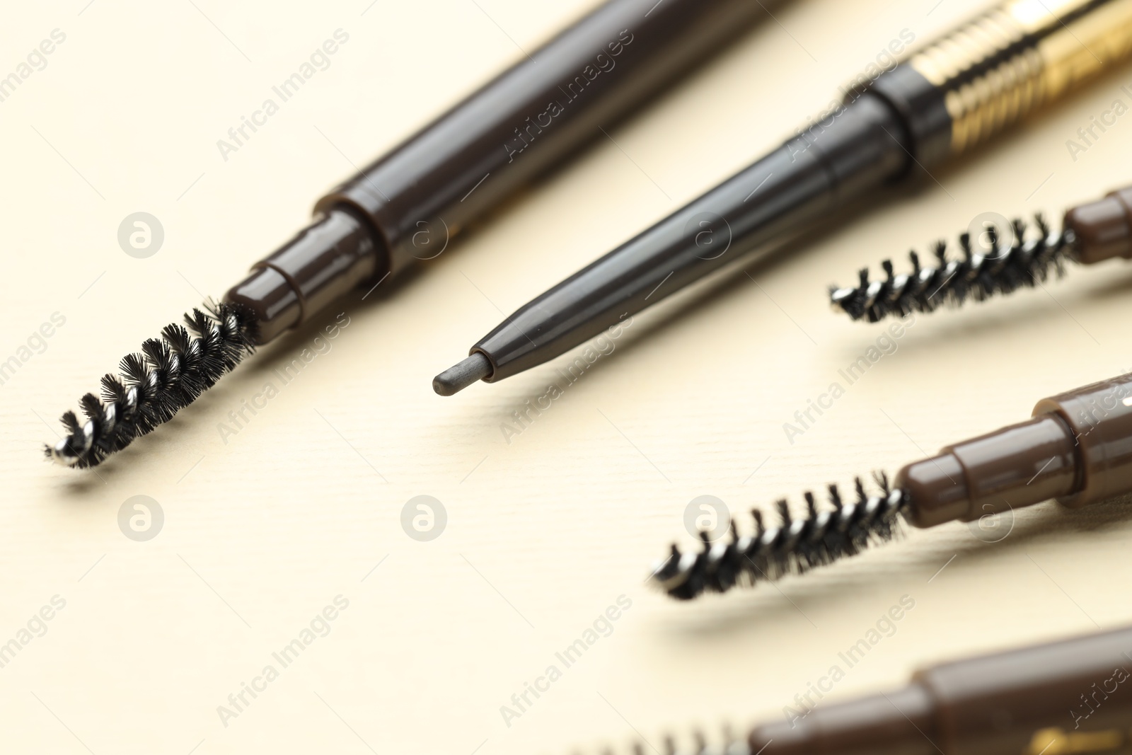 Automatic eyebrow pencils on beige background, closeup Photo of Automatic eyebrow pencils on beige background, closeup
