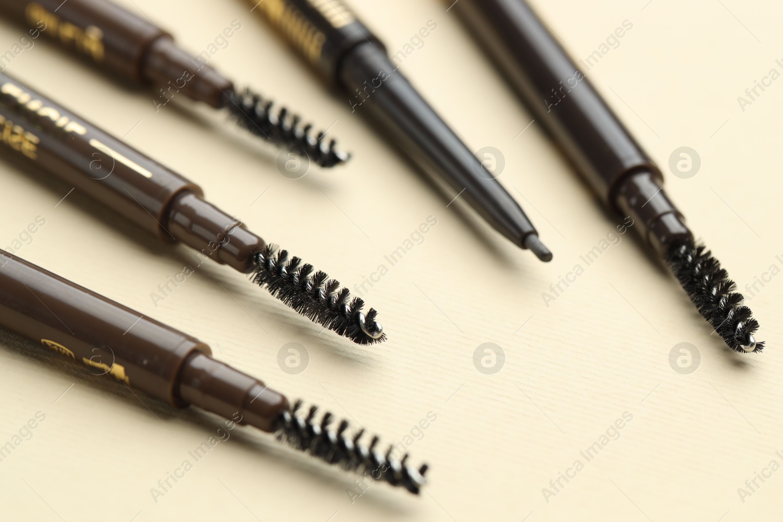 Automatic eyebrow pencils on beige background, closeup Photo of Automatic eyebrow pencils on beige background, closeup