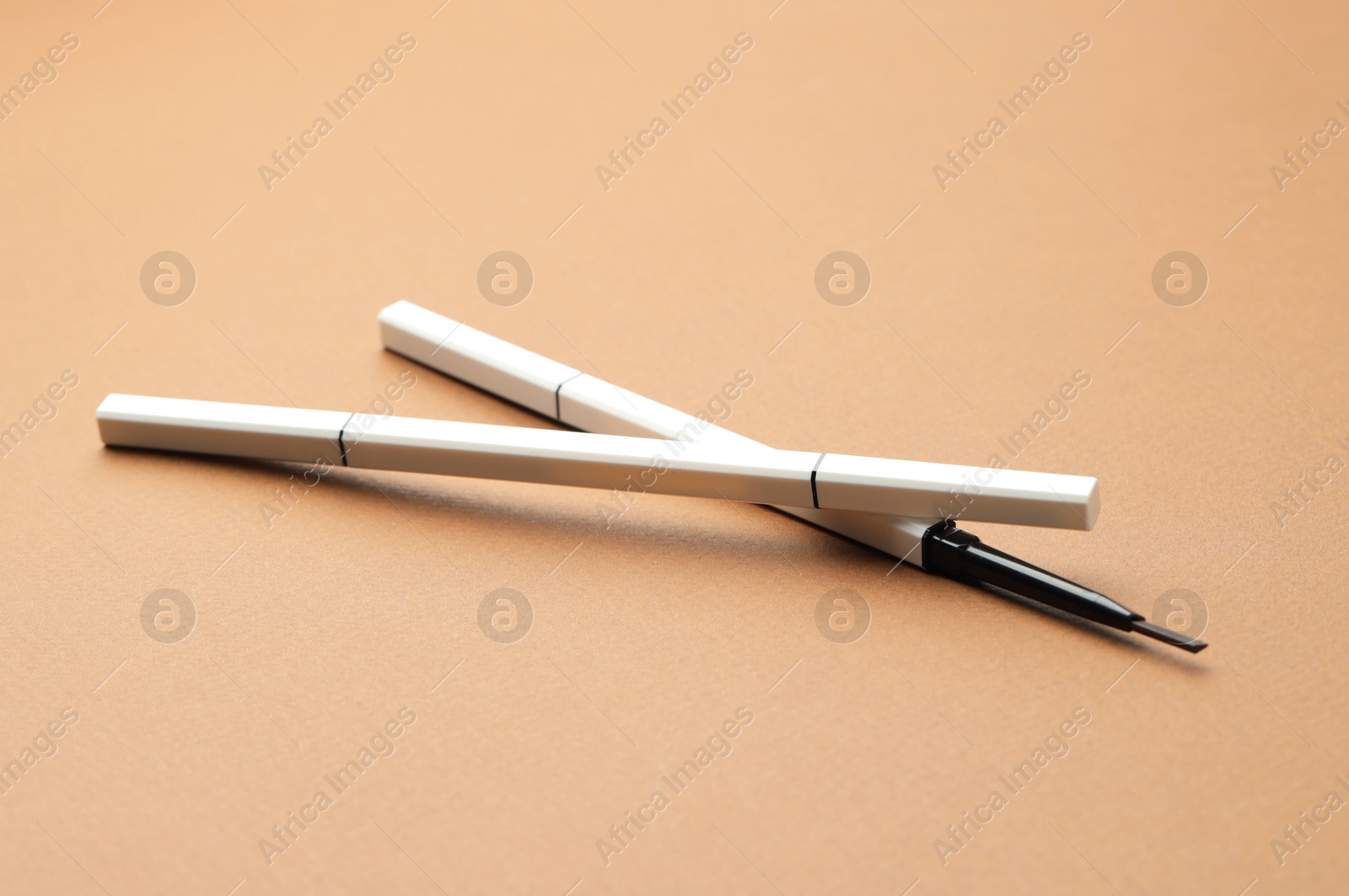 Automatic eyebrow pencils on brown background, closeup Photo of Automatic eyebrow pencils on brown background, closeup