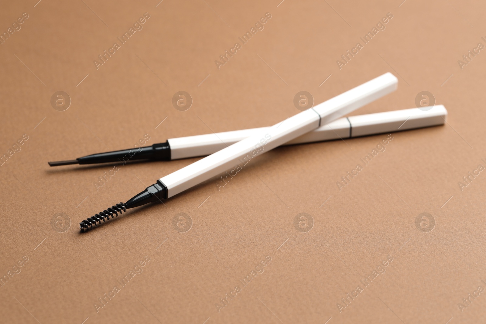 Automatic eyebrow pencils on brown background, closeup Photo of Automatic eyebrow pencils on brown background, closeup