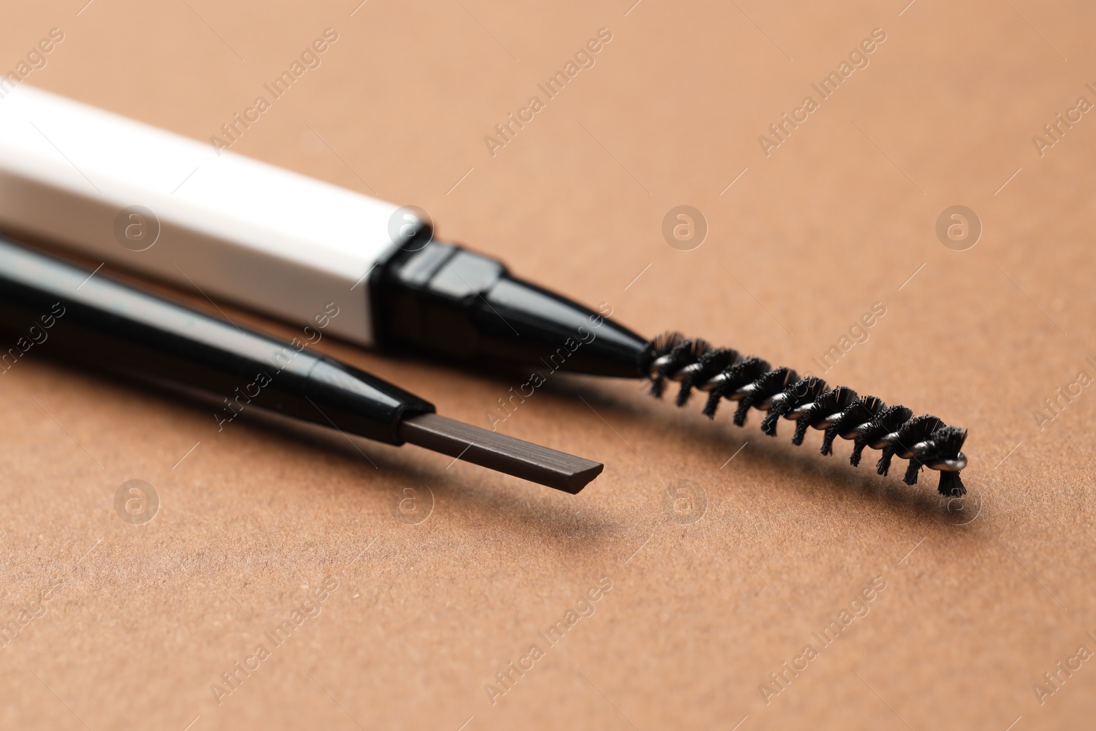 Automatic eyebrow pencils on brown background, macro view Photo of Automatic eyebrow pencils on brown background, macro view