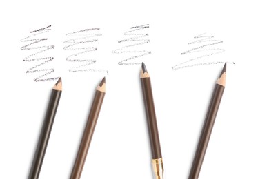 Photo of Eyebrow pencils and strokes isolated on white, top view