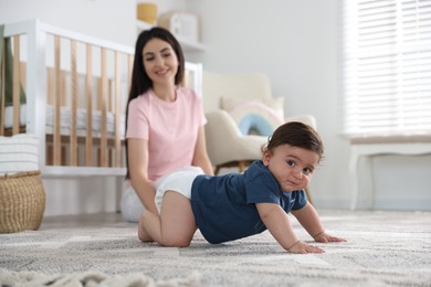 Photo of Happy mother with her cute little baby at home, selective focus