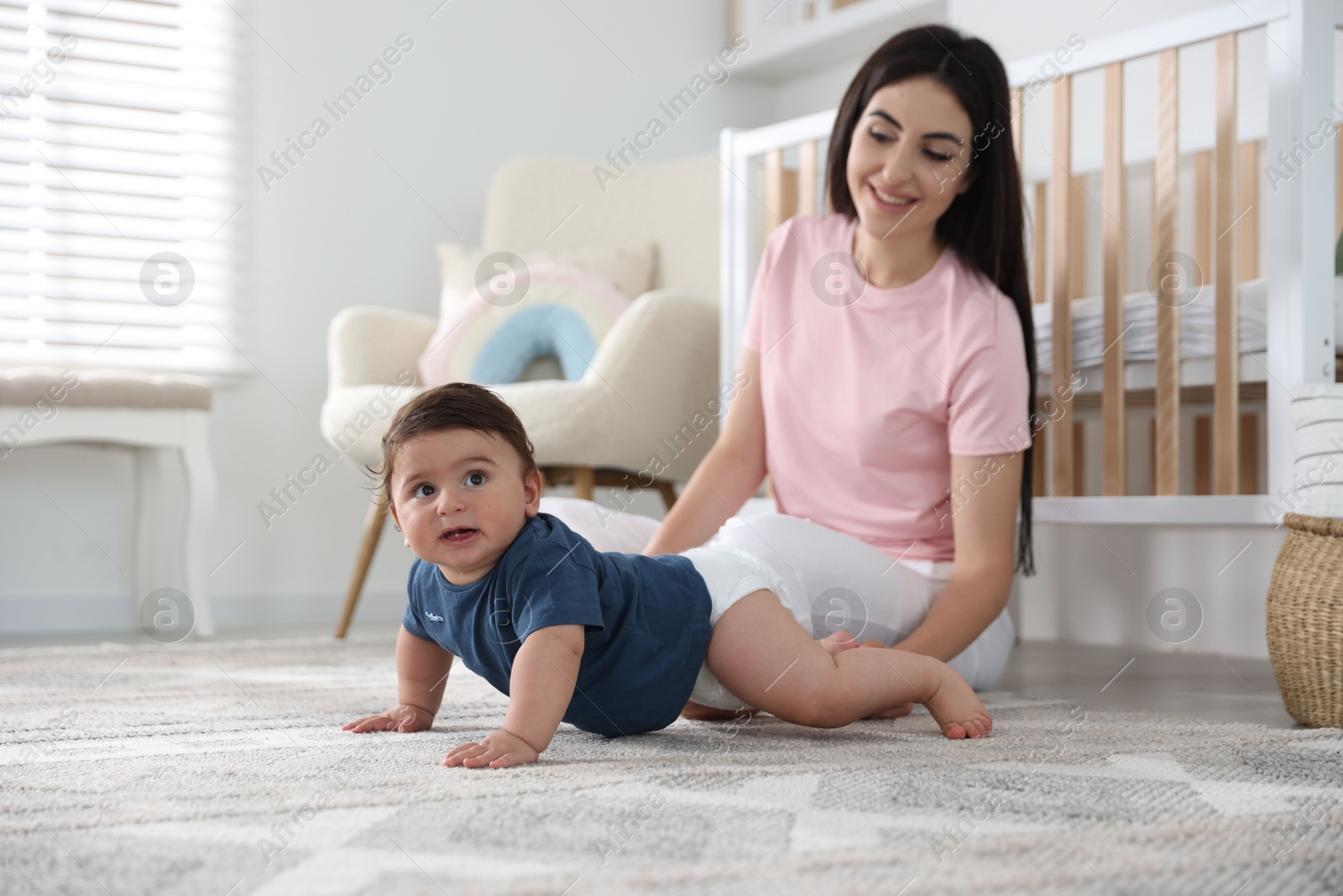 Photo of Happy mother with her cute little baby at home, selective focus