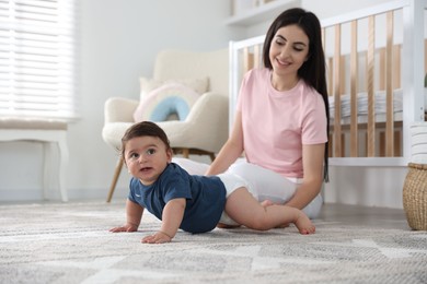 Photo of Happy mother with her cute little baby at home, selective focus
