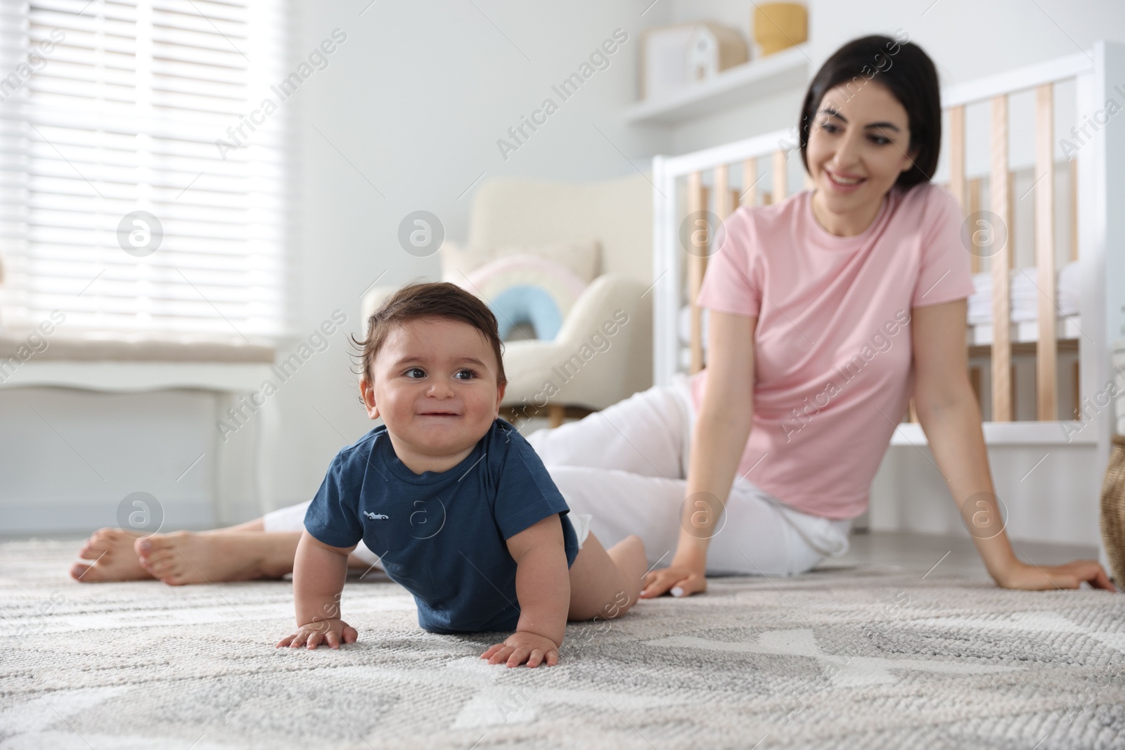 Photo of Happy mother with her cute little baby at home, selective focus