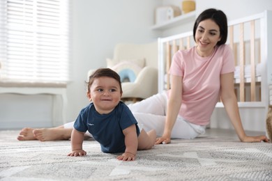 Photo of Happy mother with her cute little baby at home, selective focus