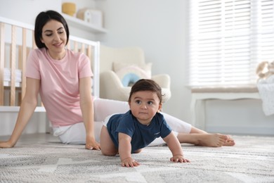 Photo of Happy mother with her cute little baby at home, selective focus