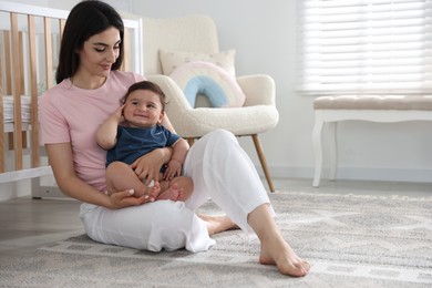 Photo of Happy mother with her cute little baby at home, space for text