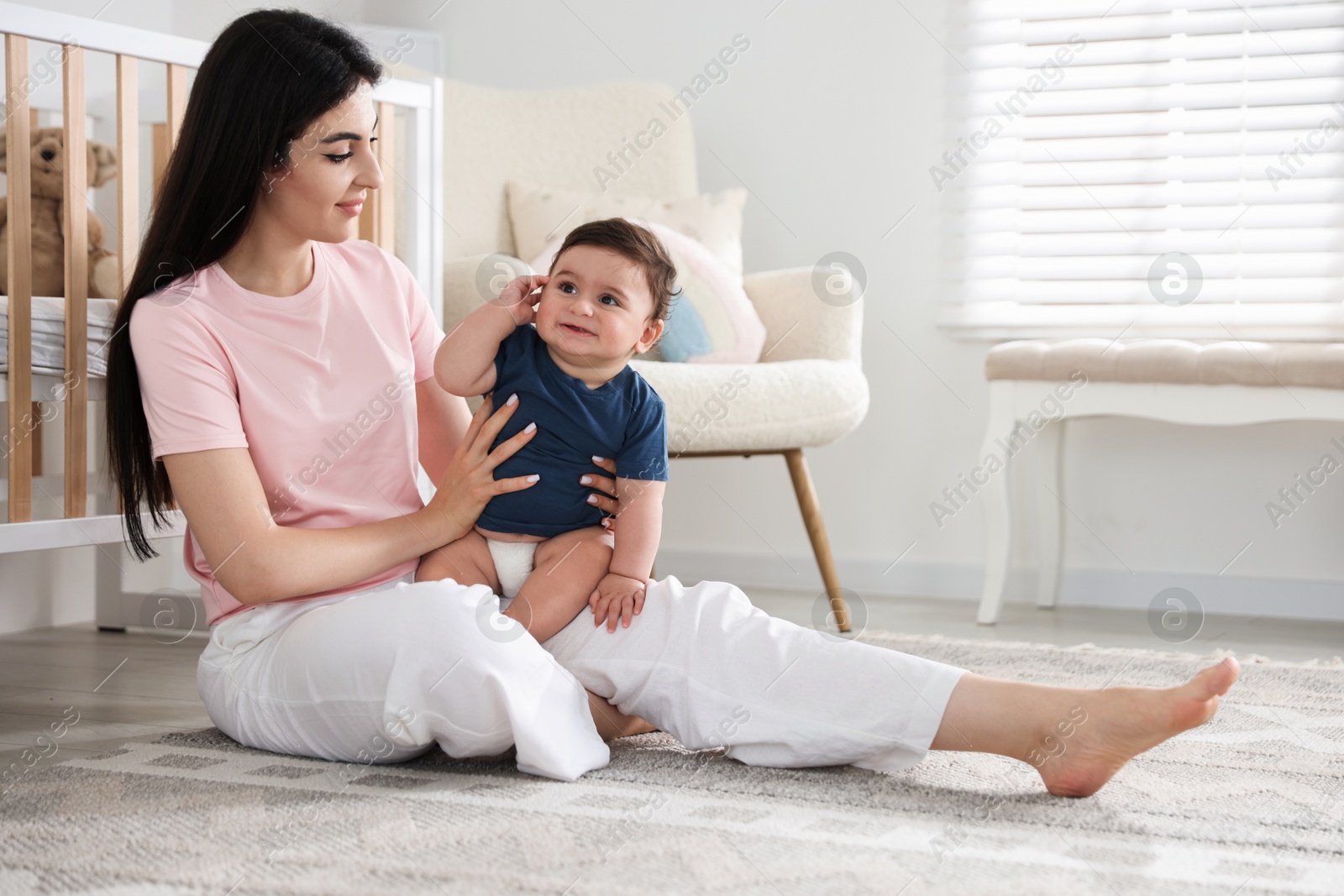 Photo of Happy mother with her cute little baby at home