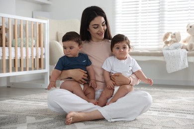 Photo of Happy mother with her cute little twin babies at home