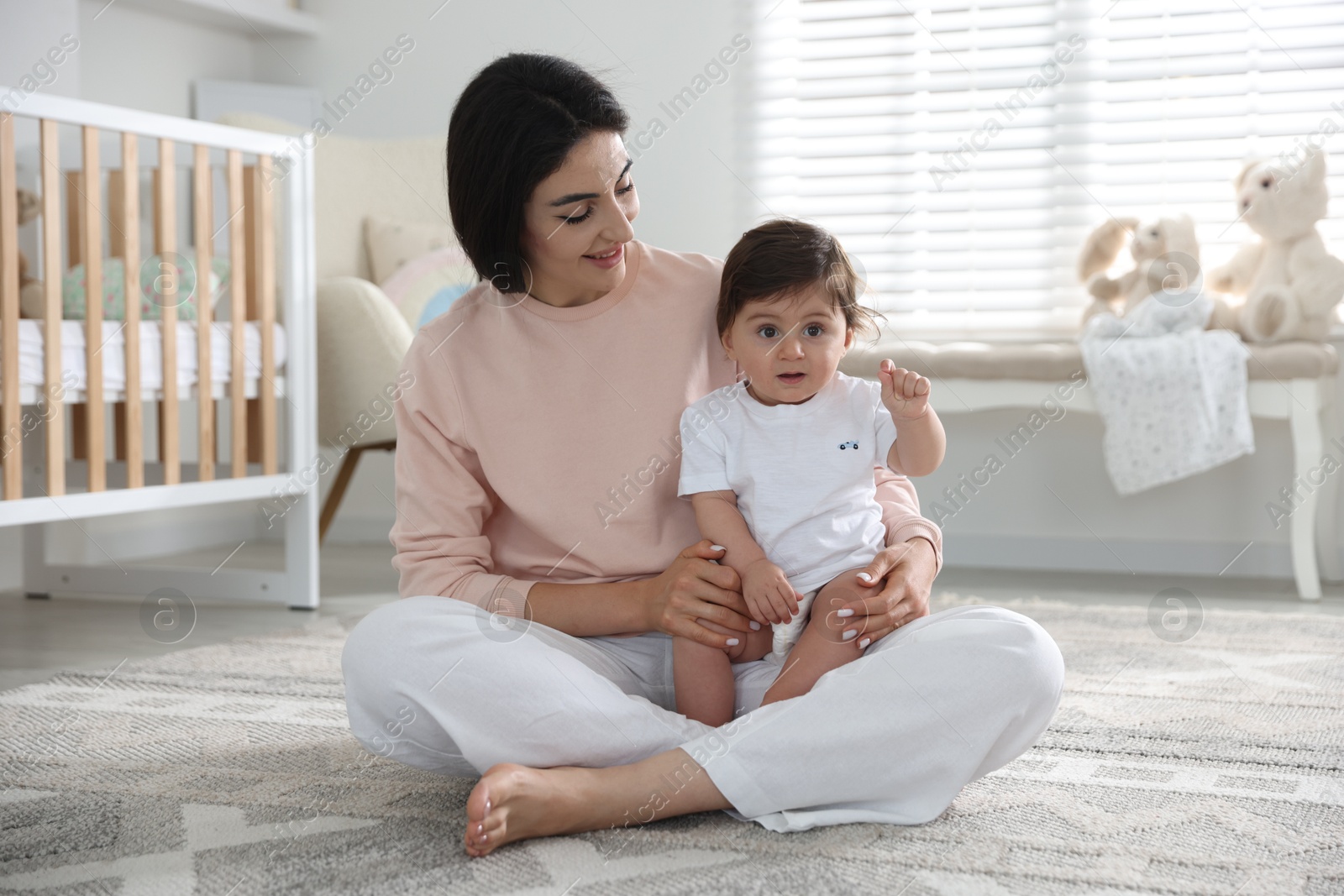 Photo of Happy mother with her cute little baby at home