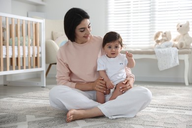 Photo of Happy mother with her cute little baby at home
