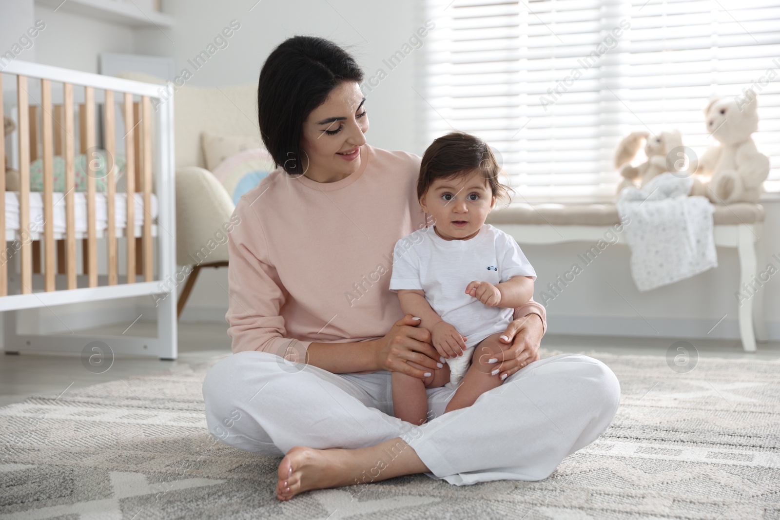 Photo of Happy mother with her cute little baby at home