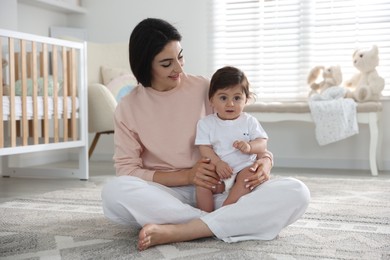 Photo of Happy mother with her cute little baby at home