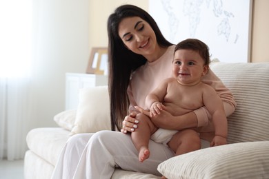 Photo of Happy mother with her cute little baby at home, space for text