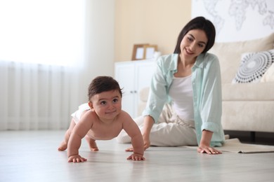 Photo of Happy mother with her cute little baby at home, selective focus