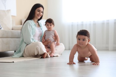 Photo of Happy mother with her cute little twin babies at home, selective focus