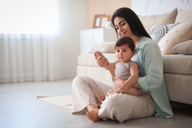 Photo of Happy mother with her cute little baby at home, space for text