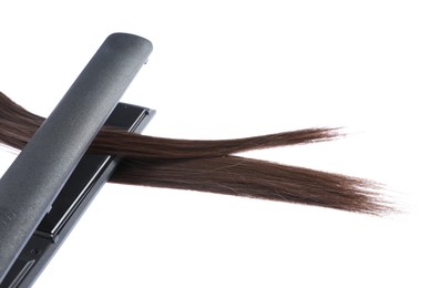 Photo of Straightener with brown hair lock isolated on white
