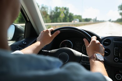 Photo of Man driving car with steering wheel, closeup