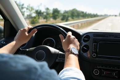 Photo of Man driving car with steering wheel, closeup
