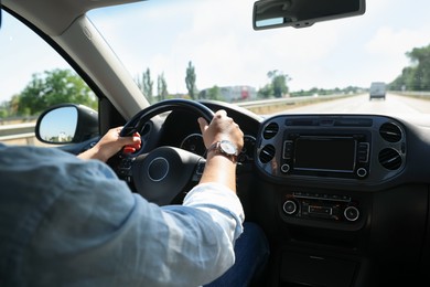 Photo of Man driving car with steering wheel, closeup