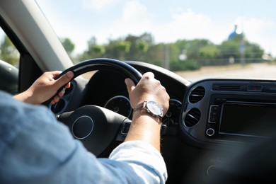 Photo of Man driving car with steering wheel, closeup