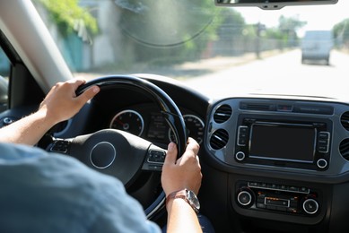 Photo of Man driving car with steering wheel, closeup