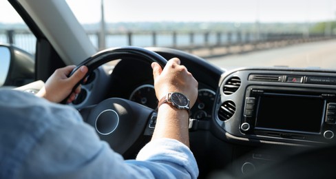 Photo of Man driving car with steering wheel, closeup