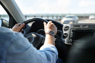 Photo of Man driving car with steering wheel, closeup
