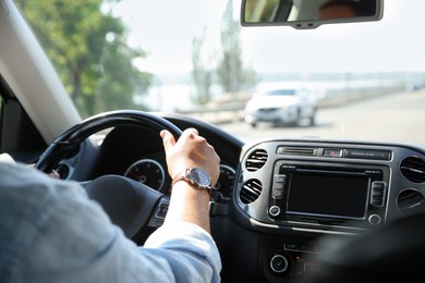 Photo of Man driving car with steering wheel, closeup