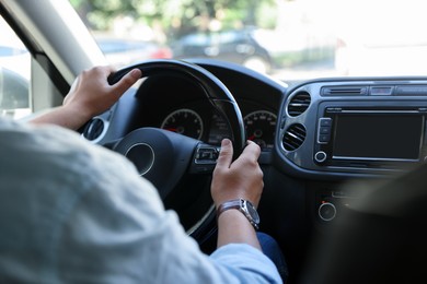 Photo of Man driving car with steering wheel, closeup