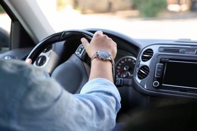 Photo of Man driving car with steering wheel, closeup