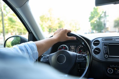 Photo of Man driving car with steering wheel, closeup