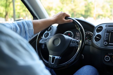 Photo of Man driving car with steering wheel, closeup