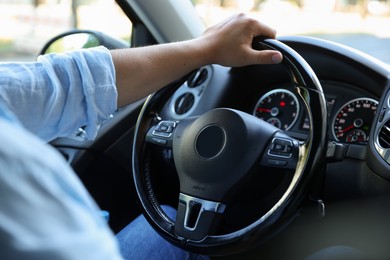 Photo of Man driving car with steering wheel, closeup